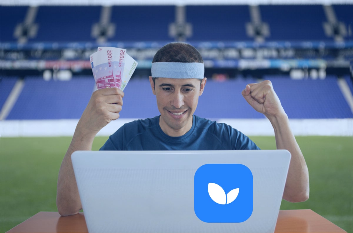 Мужчина смотрит в ноутбук и держит деньги